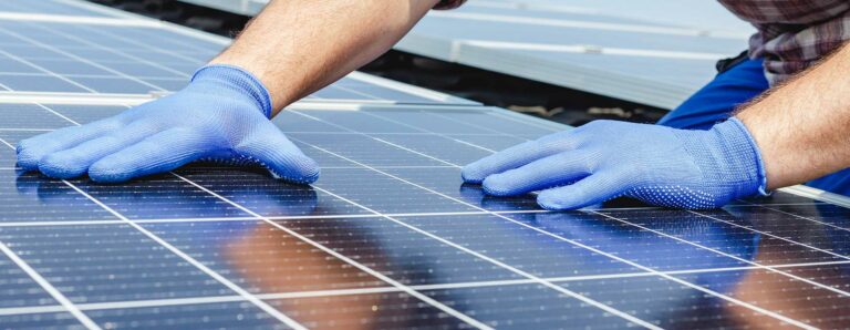 Ein Handwerker richtet sorgfältig die Elemente eine Photovoltaikanlage aus.